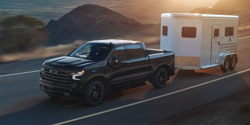 Man unloading luggage in tailgate of black truck